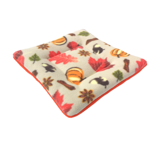 Padded guinea pig sleeping mat with a soft fleece surface, featuring an autumn leaves print. Ideal for small pets to rest comfortably in cages or playpens.